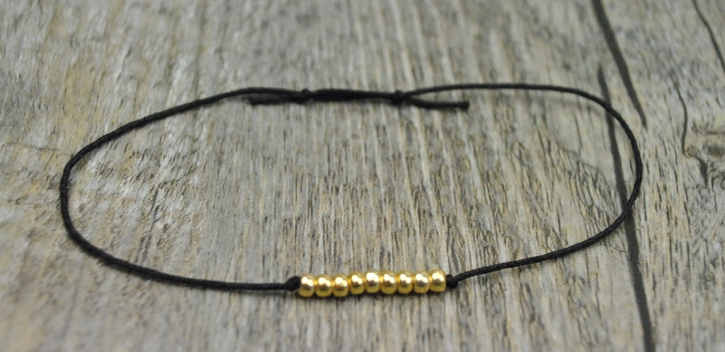 Armband mit goldenen Kugeln und Band in schwarz